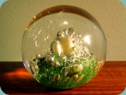 Brevpress i klarglas med bubblor på grön
                          botten