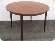 Round dining table with
                          extension leaves, rosewood imitating
                          laminate.