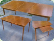 Rektangulärt matbord i
                          teak med svängda långsidor och iläggsskiva