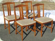Fyra stolar i teak med
                          sliten textilklädsel, 50-tal eller 60-tal