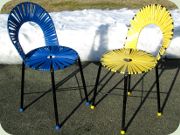 Paret stolar i
                          svartlackad metall, sits och rygg lindade med
                          plastband i gult respektive blått
