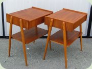 A pair of Swedish 50's
                          or 60's teak bedside tables with drawer and
                          rattan magazine shelf by Carlström & Co